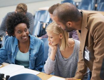 Three adults having a discussion in a college setting.