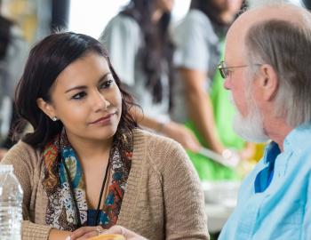 Two teachers having a discussion over lunch.