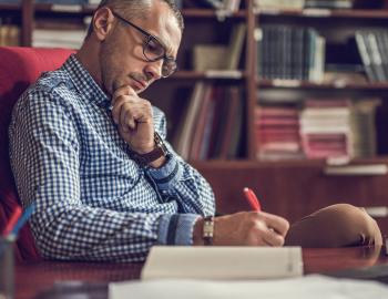 A principal writing at a desk.