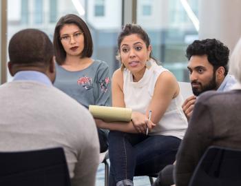 Group of seated adults having a discussion.