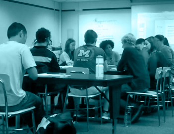 Professor speaking to college students in a classroom.