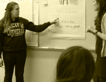 A student teacher presenting in front of a whiteboard.