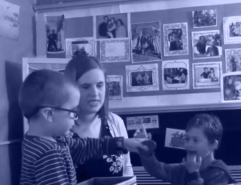 Preschool teacher helping students with an activity.