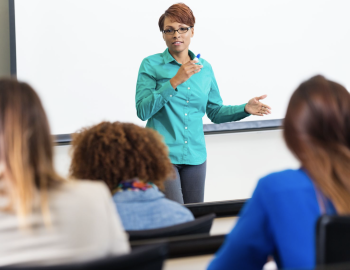A women speaking in front of a classroom.