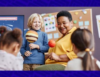 A teacher showing elementary students a planetary model.