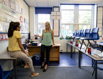 Two educators talking in a classroom.