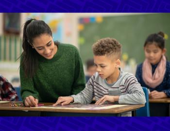 A young teacher helping an elementary student with an assignment.