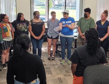 Group of student teachers standing in a circle for a group project.