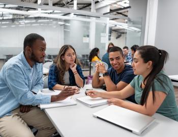 A group of college students having a discussion in a classroom.