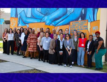 Group of educators in front of an outdoor mural.