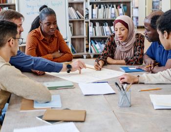 Group of adult students discussing an assignment.