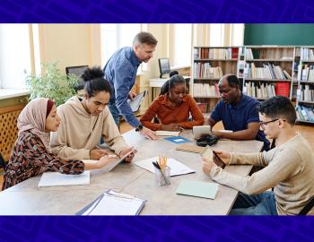 Group of adult students and teacher working collaboratively.